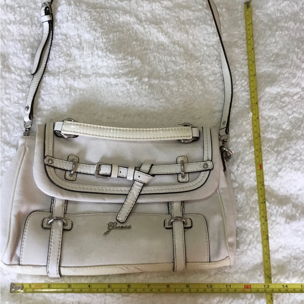 White handbag decorated with buckles.
